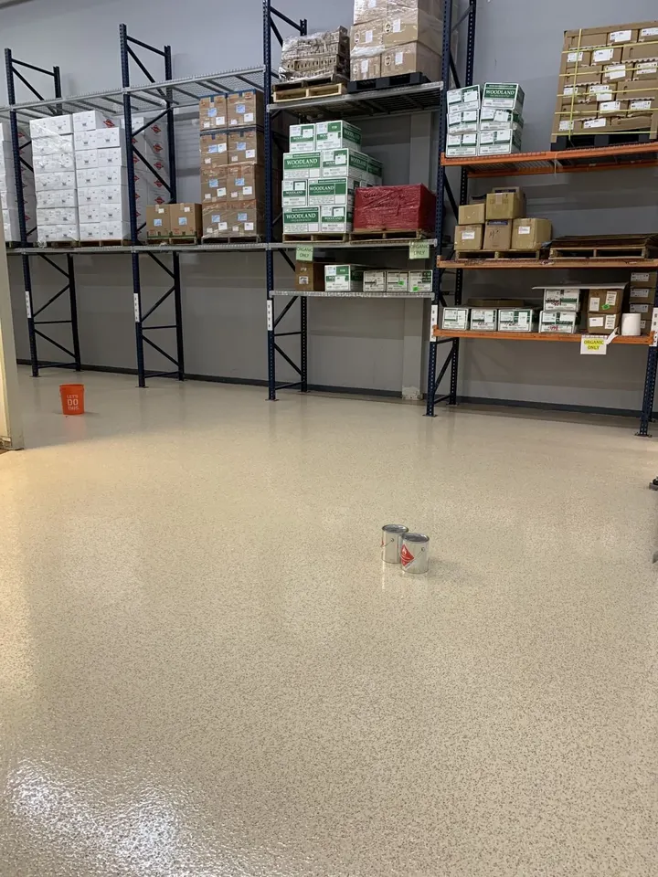 Tan flake floor in a commercial warehouse with pallet racking